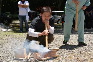 火起こしの実演② 種火に空気を送り火を起こします。